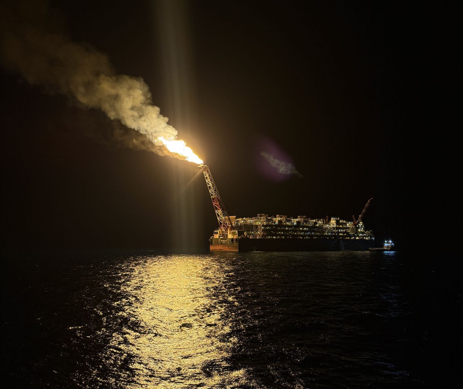 FPSO em posição à noite, com tocha
